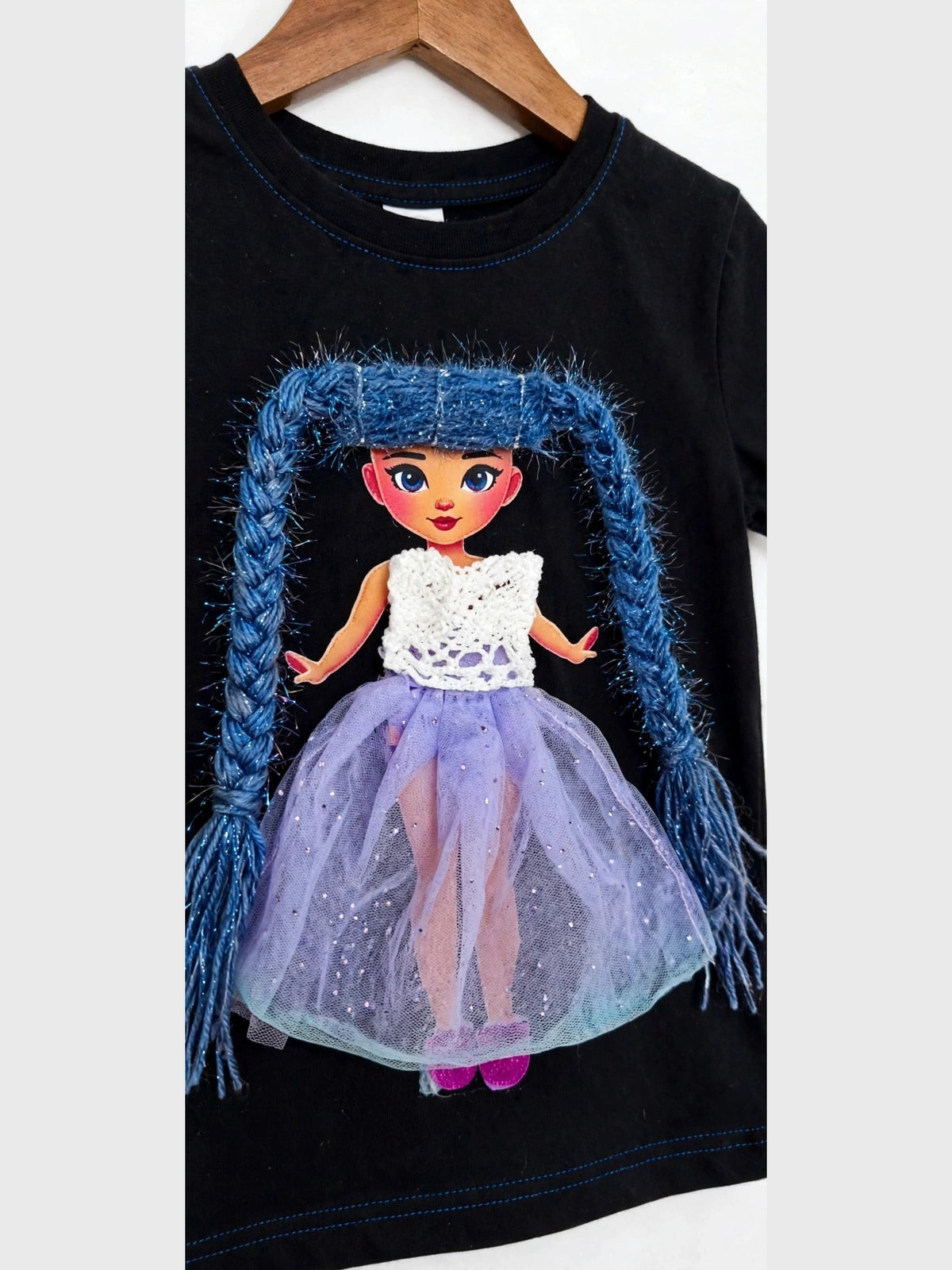 Handmade blue hair doll design in purple skirt on black T-shirt, product photo