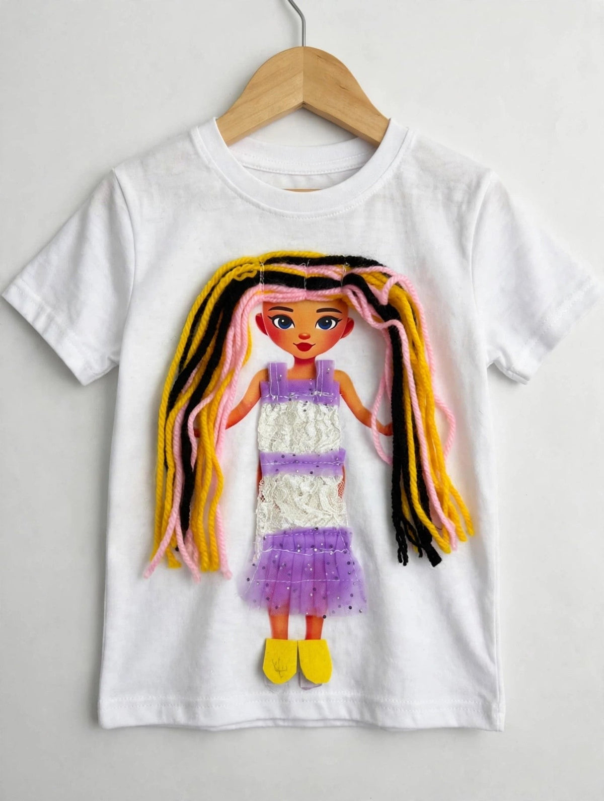 White T-shirt with handmade doll appliqué, streaked yarn hair and lace dress