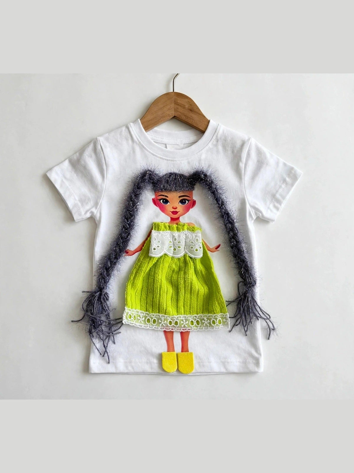 White T-shirt with handmade doll appliqué, dark yarn hair and green dress