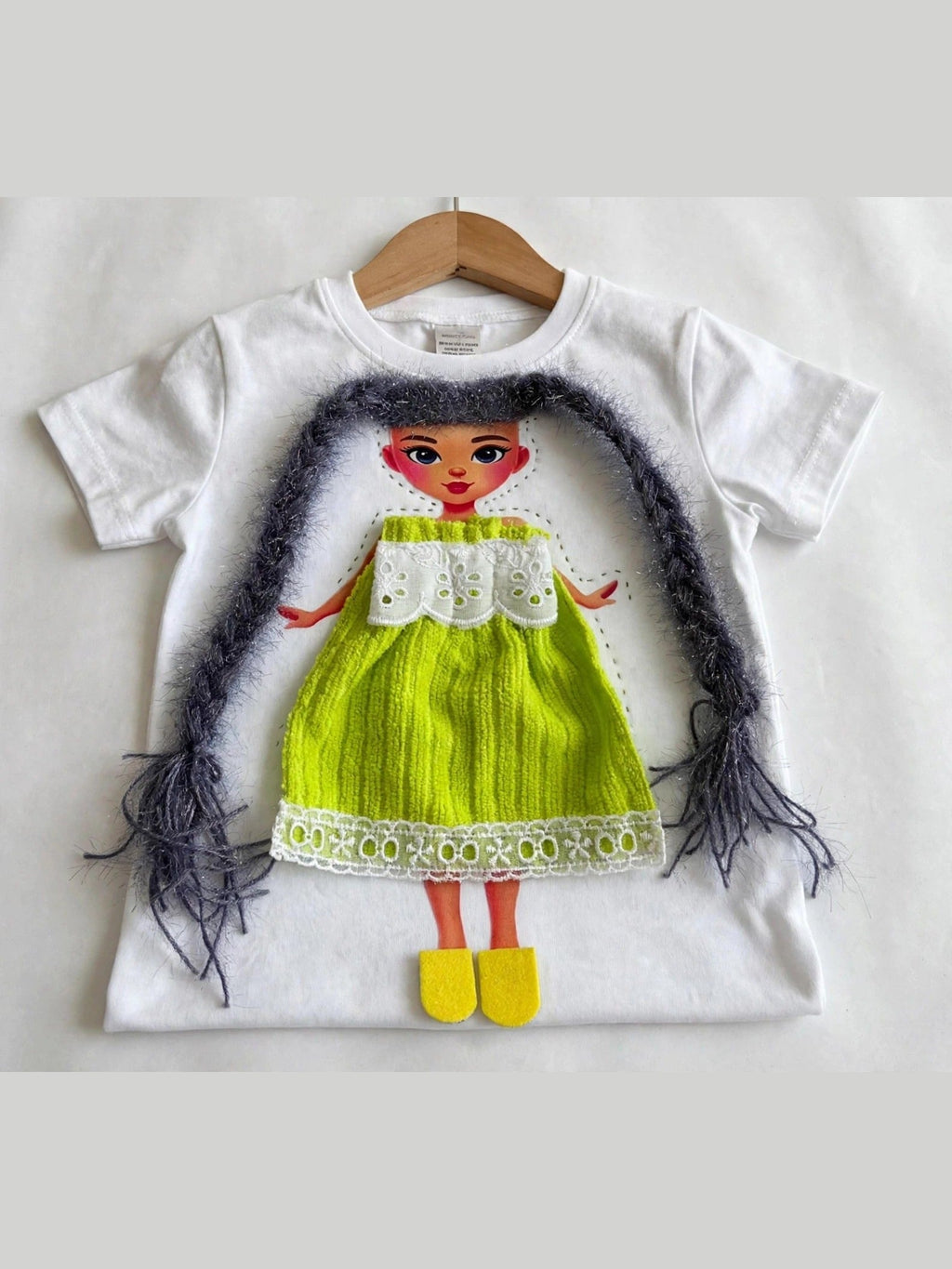Handmade dark hair doll design in green dress on white T-shirt, product photo